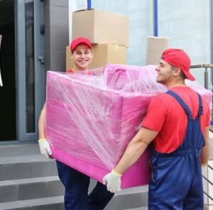 Umzug in Meiningen Zwei Umzugshelfer tragen ein in Folie gepacktes Möbelstück – Umzug in Meiningen