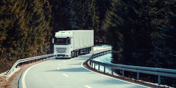 Klaviertransport Meiningen: Lkw fährt auf einer kurvigen Straße durch den Wald