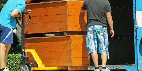Möbellift Meiningen: Zwei Helfer tragen einen Holzschrank aus einem Lkw
