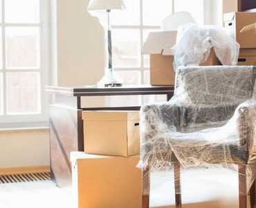 Kartons zwischen Sesseln in einem hellen Zimmer – Umzugskartons Meiningen